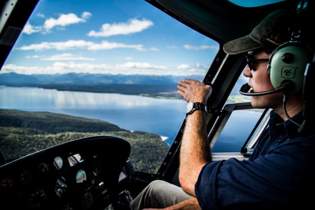 A helicopter pilot points to the scenery from above in Fiordland National Park New Zealand