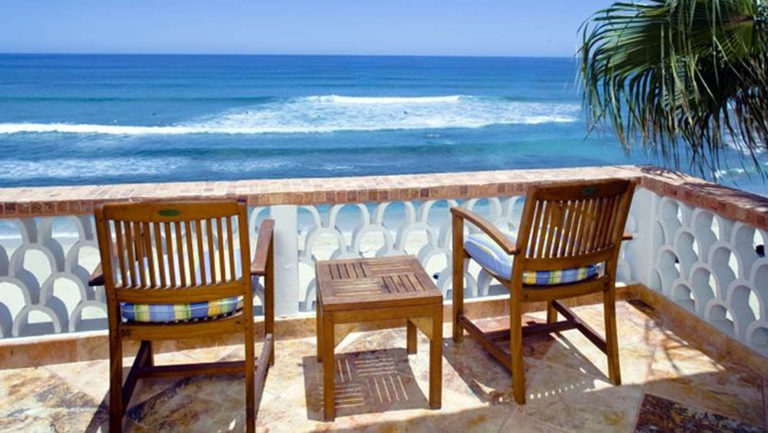 Two chairs and a table on a sunny balcony overlooking the ocean in Baja California, Mexico, at the Cabo Surf Hotel and Spa