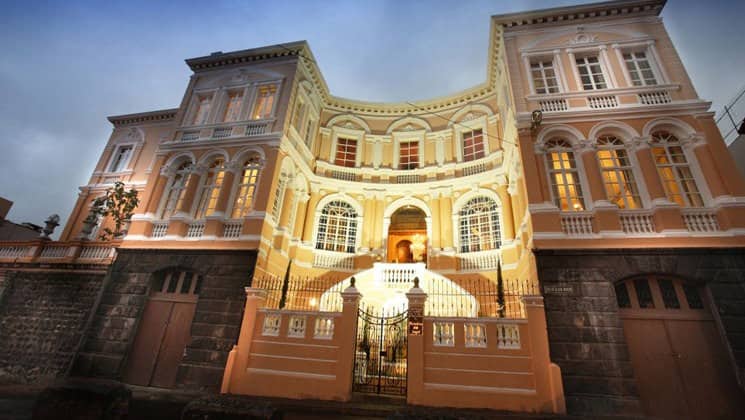 At dusk with lights illuminating the exterior facade of the Mansion del Rio, a premier boutique hotel in Guayaquil, Ecuador