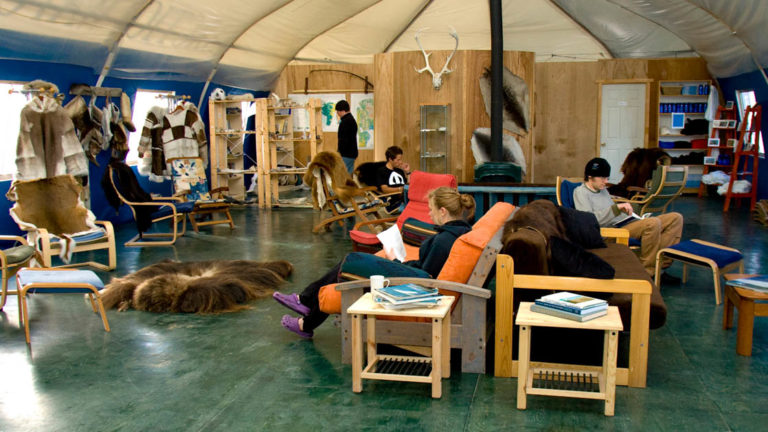 Arctic Watch large group tent with chairs and couches full of people hanging out.