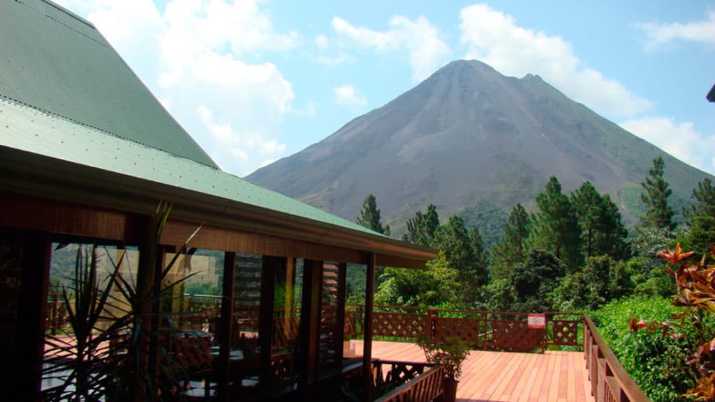 Sunny deck of main lodge at Arenal Observatory Costa Rica Lodge with Arenal Volcano in background
