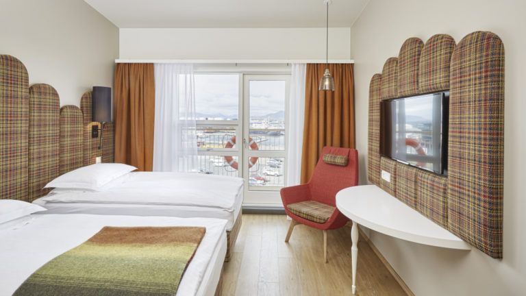 The twin deluxe room, with two full beds, a flat-screen tv and large windows overlooking the harbor, at the contemporary Icelandair Reykjavik Marina Hotel
