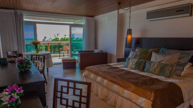 The spacious junior suite at Iguana Crossing Boutique Hotel with a king-sized bed, a ocean-front views, and and a private balcony overlooking the beachfront in Puerto Villamil on Isabela Island in the Galapagos