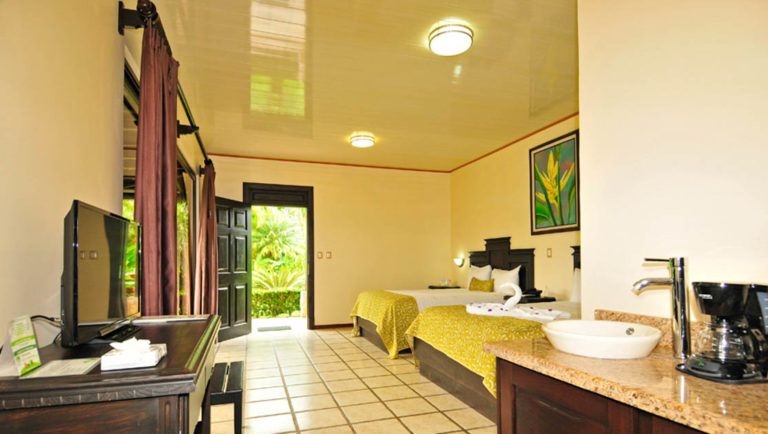 The vanity, coffee maker, and television make a stay in the junior suite at the Arenal Manoa Lodge comfortable