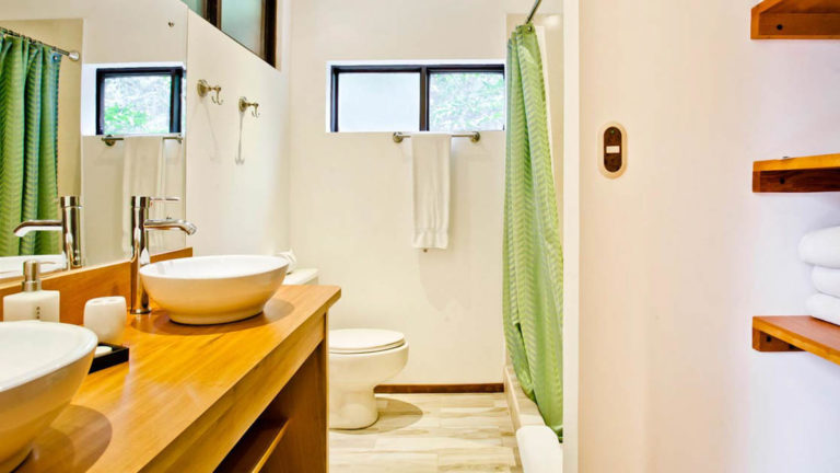 The bathroom inside the forest view balcony room has two sinks, a vanity, bathroom, and solar-heated hot showers at the Monteverde Lodge, a sustainable, nature retreat on the edge of a well-known cloud forest in Costa Rica