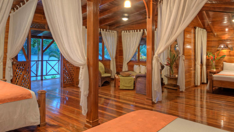 The River View Penthouse Suite with one king and one queen Bed closed off by gauze curtains, at the Tortuga Lodge, one of Costa Rica's most environmentally conscious accommodations.