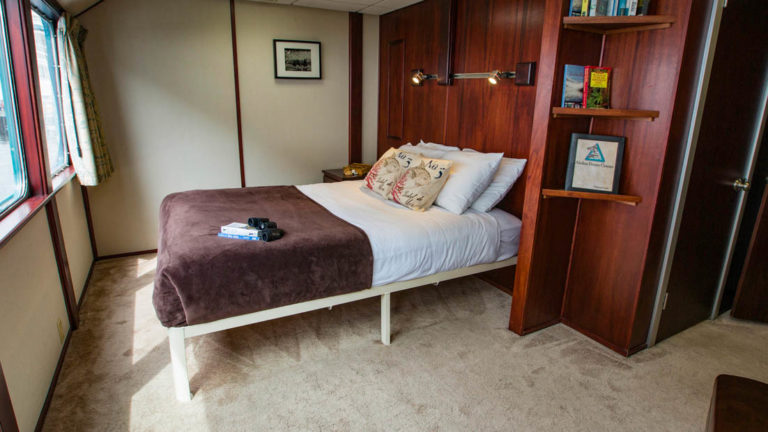 Owner's Suite aboard Alaskan Dream with large bed and window.