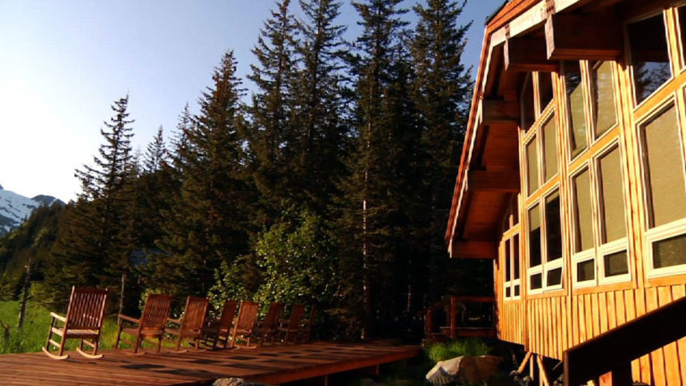 The exterior of the sustainable, eco Kenai Fjords Glacier Lodge, which is nestled in Alaskan forest and offers 16 comfortable log cabins.