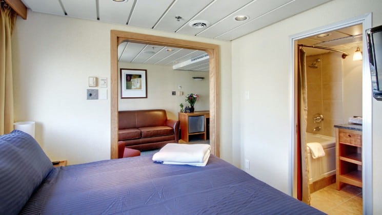 Commodore suite with large bed and an adjoining room with a comfortable couch in it aboard the safari Endeavour Baja small ship