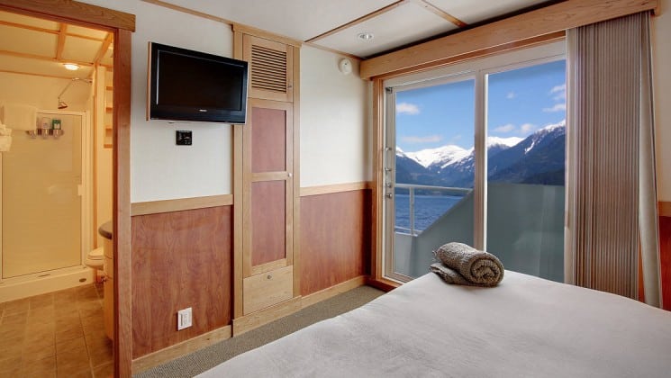 captain stateroom aboard the Safari Quest Alaska small ship, with a large bed, flat screen tv and large picture windows