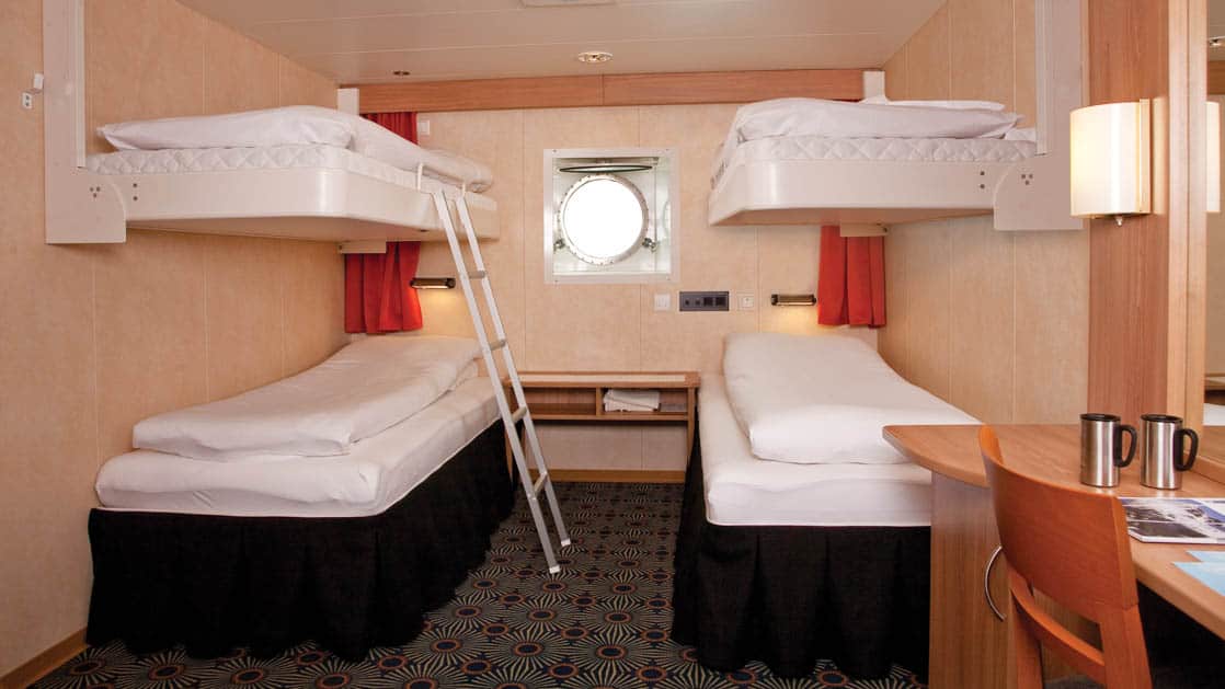 Expedition Quad stateroom with 4 berths, ladder, desk and porthole.