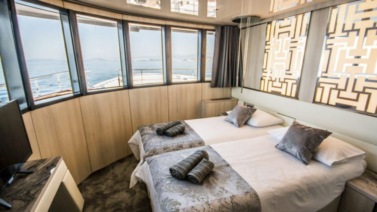 VIP Upper Deck cabin aboard Black Swan with large windows and beds together.