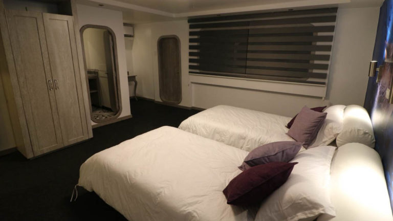 Stateroom with twin beds, windows, and wordrobe aboard Camila