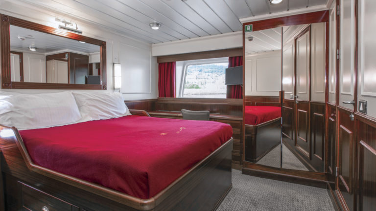 Lord of the Glens stateroom with double bed, closet, large window and desk.
