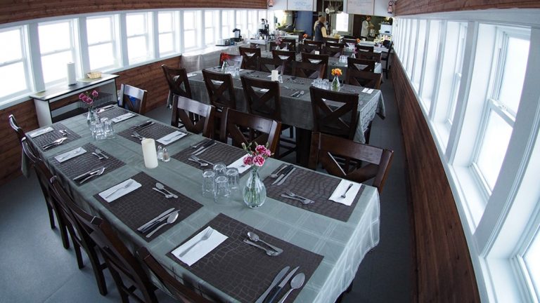 The dining room with tables set for a meal at the Tundra Lodge, is a unique, rolling hotel, located in the subarctic outside the small Canadian frontier town of Churchill, Manitoba