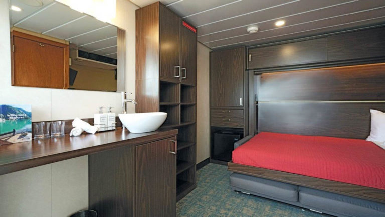 Admiral cabin with queen wallbed in bed configuration aboard Wilderness Explorer
