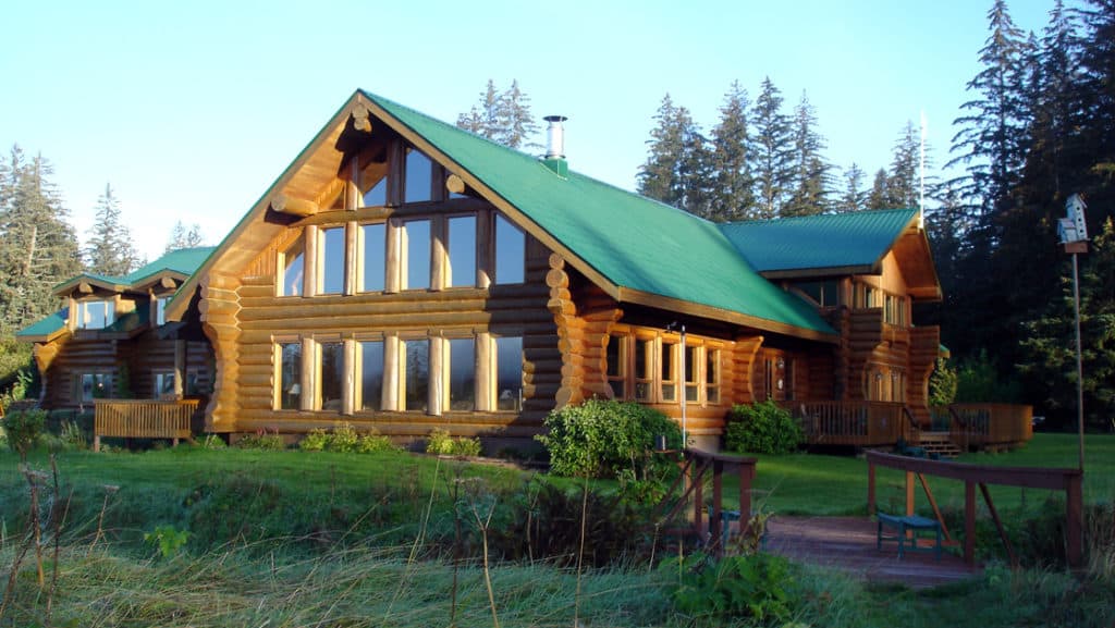 Large windows at the Bear Track Inn face large growth forest, open meadows, and views of Icy Strait in Alaska