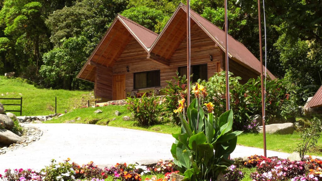 A picutre of the two pitched Boquete Tree Mountain Resort with flowers in the front.