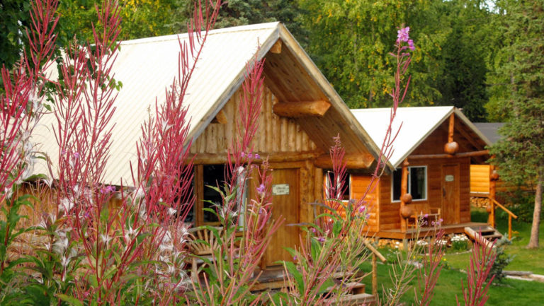 Flowers bloom in front of wood cabins at the Winterlake Lodge, an Alaska resort recognized by National Geographic for its wilderness experience