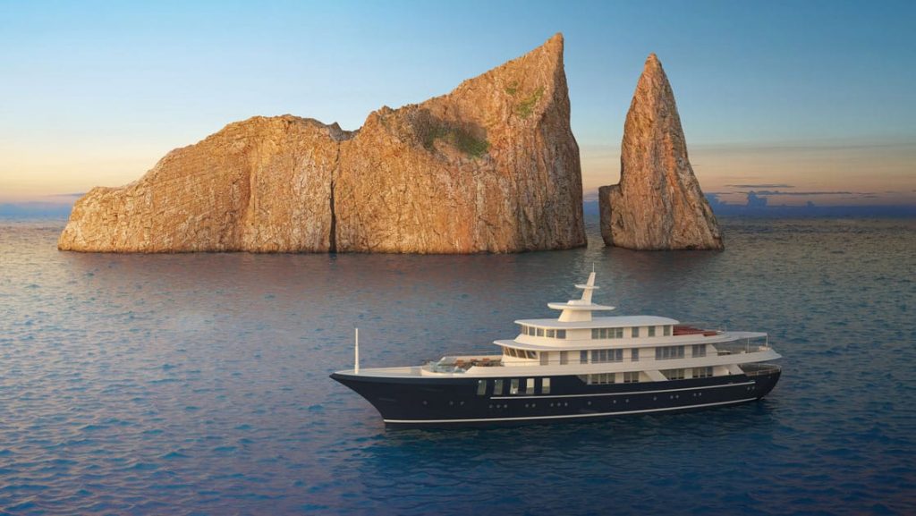 Rendering of Conservation Galapagos yacht with dark blue hull & white upper decks sitting beside large beige rocks at sunset.