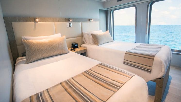 origin and theory luxury ship cabin with 2 twin beds with an ocean view