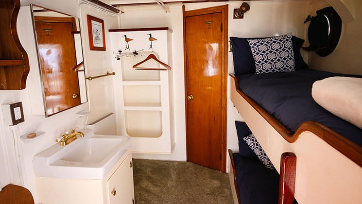 cabin six aboard sea wolf small Alaska ship, two bunk beds with porthole windows with a sink, mirror and closet