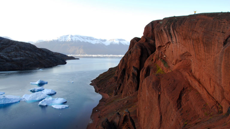 red cliffs with icebergs below seen on the three arctic islands iceland, greenland, spitsbergen small ship cruise