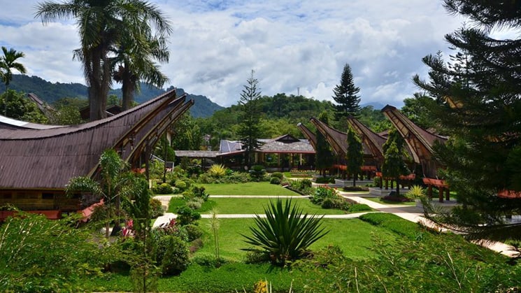 The courtyard at Toraja Misiliana Hotel with traditional buildings surrounding.