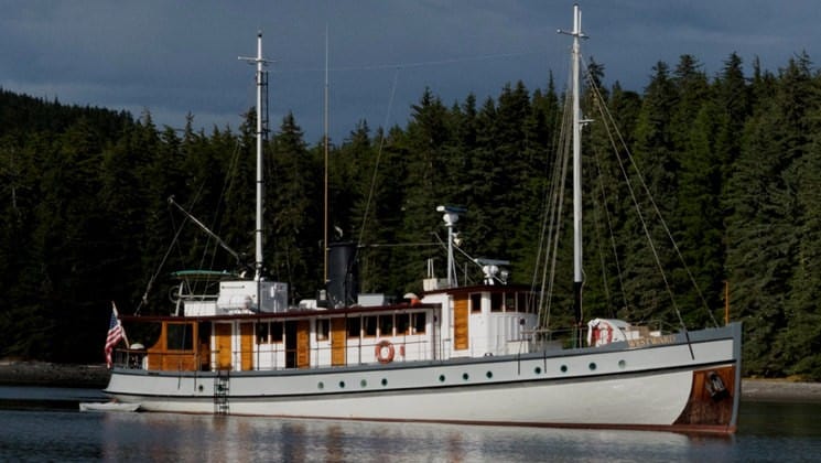 Westward exterior picture of starboard side with pine trees in background