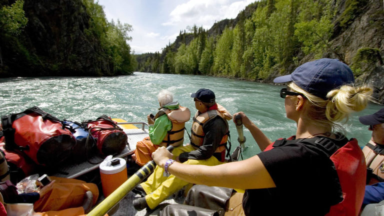 Group of guests on a river rafting excursion in alaska with their guide