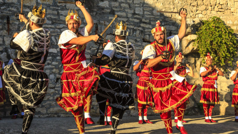 A group of men sword dancing in Old Town Korcula, as seen from the under sail small ship cruise from Greece to the Dalmatian coast