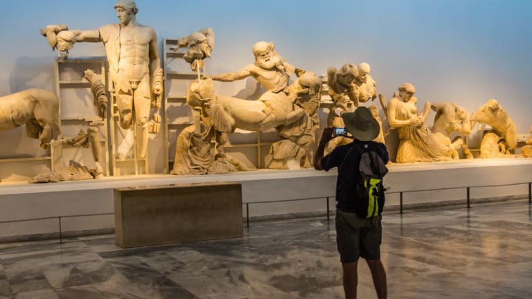 a male guest taking photos of statues in museum of Olympia Archaeological Site, Greece, seen from the under sail small ship cruise from Greece to the Dalmatian coast