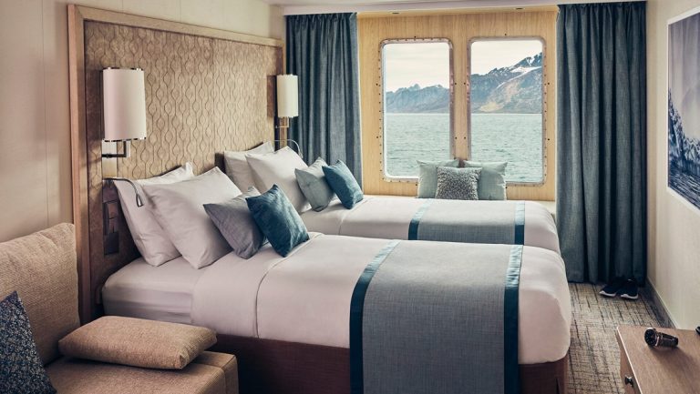 Rendering of Window Suite with two twin beds, couch, desk and large window aboard National Geographic Resolution polar expedition ship.