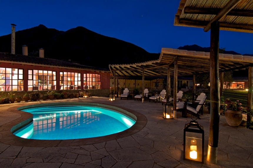 the pool area at Sol Y Luna, a Peru Lodge inside the Sacred Valley, it is night time, the pool lit with lights