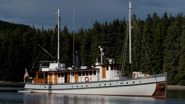 Westward exterior picture of starboard side with pine trees in background.