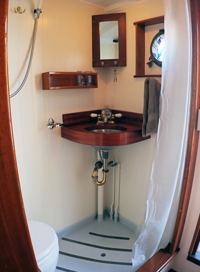 Private bathroom and shower inside Cabin #6 aboard Catalyst small ship. Sink, porthole, shower and toilet all in one shared area.
