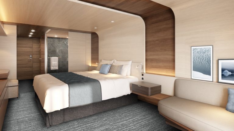 Rendering of cabin aboard Le Commandant Charcot ship, with beige & blue color theme, double bed, couch & bathroom.