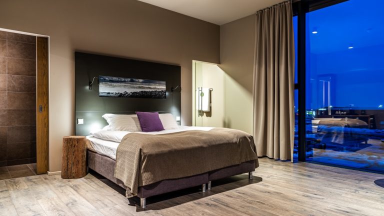 Deluxe room at Hotel Vik i Myrdal with king-size bed, floor-to-ceiling windows, wooden floor & contemporary feel.