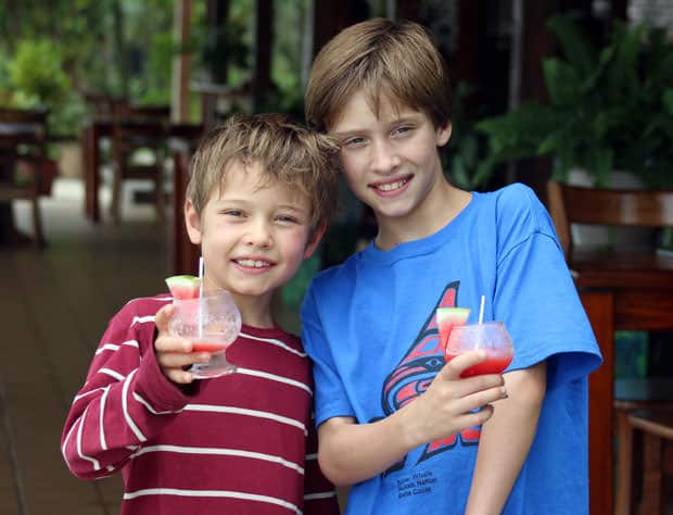 Young travelers enjoying a watermelon mocktail in Costa Rican lodge.
