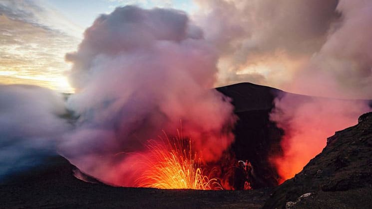 Volcano erupts, shooting hot magma & clouds skyward, seen on the Tahiti to Fiji: Reefs, Lagoons & Volcanic Isles cruise.