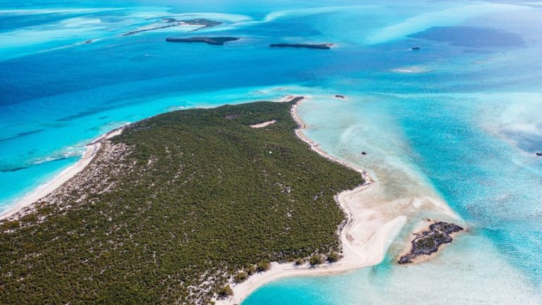 Aerial view of The Exumas islands with white-sand beaches, green interiors & turquoise water, seen on a Bahamas small ship cruise.